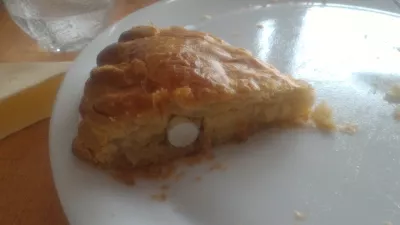 Galette des rois history of frangipane delight : The feve from a kings cake visible in a slice