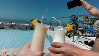 How to get free hotel nights – choose a reward program : Enjoying a cocktail by the pool of the Radisson Cartagena Ocean Pavillion Hotel in Colombia, where we stayed with free reward nights using the Radisson Rewards points