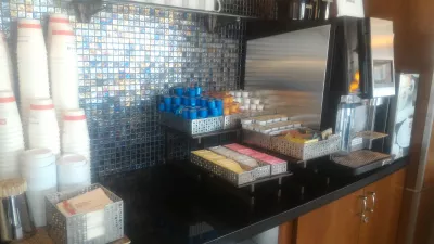 ¿Cómo acceder al United lounge LAS, y cómo es? : Cafetera y rincón de té con tazas para llevar.