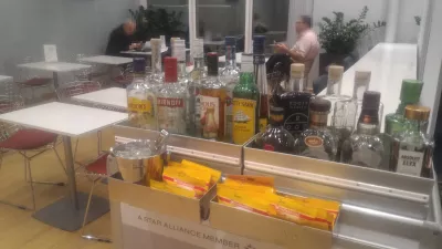 StarAlliance Aegean Athens non-Schengen lounge : Hard liquors selection on a tray and food seating area