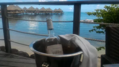 Quali sono i migliori bungalow di lusso sull'acqua nei resort della Polinesia francese? : Bere vino tahitiano durante il pranzo con vista sul bungalow sull'acqua di Tahiti presso il resort sulla spiaggia di Tahiti Ia Ora gestito da Sofitel