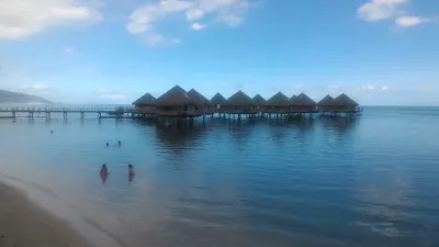 Quali sono i migliori bungalow di lusso sull'acqua nei resort della Polinesia francese? : Spiaggia di sabbia bianca sulla laguna di Tahiti di fronte ai bungalow sull'acqua