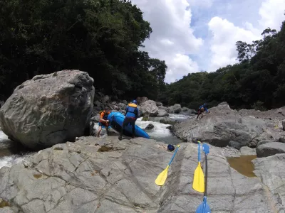 White water rafting adventure on Mamoni river Panama : Moving inflatable river raft manually 