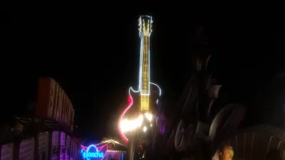Walking on the best parts of Las Vegas strip up to the neon museum : Hard Rock café giant guitar neon sign, former tallest neon sign in the world, at neon museum