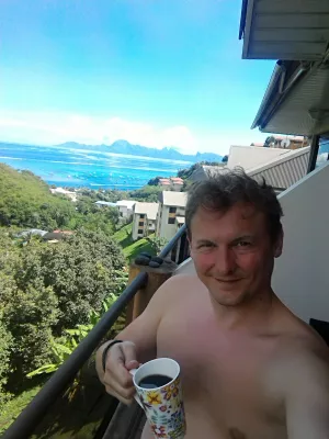 Cilat janë vendet më të mira për të qëndruar në Tahiti? : Pirja e kafesë nga ballina e një AirBNB në Tahiti me pamje mbi lagunën Tahiti dhe ishullin Moorea