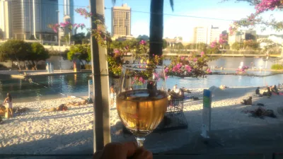 Unique and cheap things to do in Brisbane to never be bored in Brisbane! : Glass of wine on an outdoor terrace at SouthBankBeerGarden bar with view on the swimming pool
