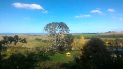 Hobbiton filmset tour, een bezoek aan het hobbitdorp in Nieuw-Zeeland : Zicht op het feestveld vanuit het huis van Bilbo