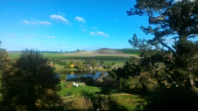 Hobbiton filmset tour, een bezoek aan het hobbitdorp in Nieuw-Zeeland : Uitzicht op de Green Dragon Inn vanaf de top van de heuvel