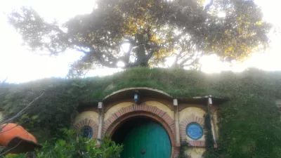 Hobbiton movie set tour, a visit of the hobbit village in New Zealand : La maison de Bilbo et un arbre au sommet de la colline