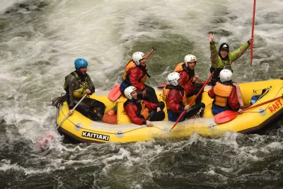 Extreme white water rafting in Rotorua, New Zealand: down a 7 meters waterfall! : Cheering after having successfully rafted the waterfall