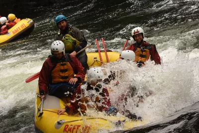 Extreme white water rafting in Rotorua, New Zealand: down a 7 meters waterfall! : Water rapids getting in the raft